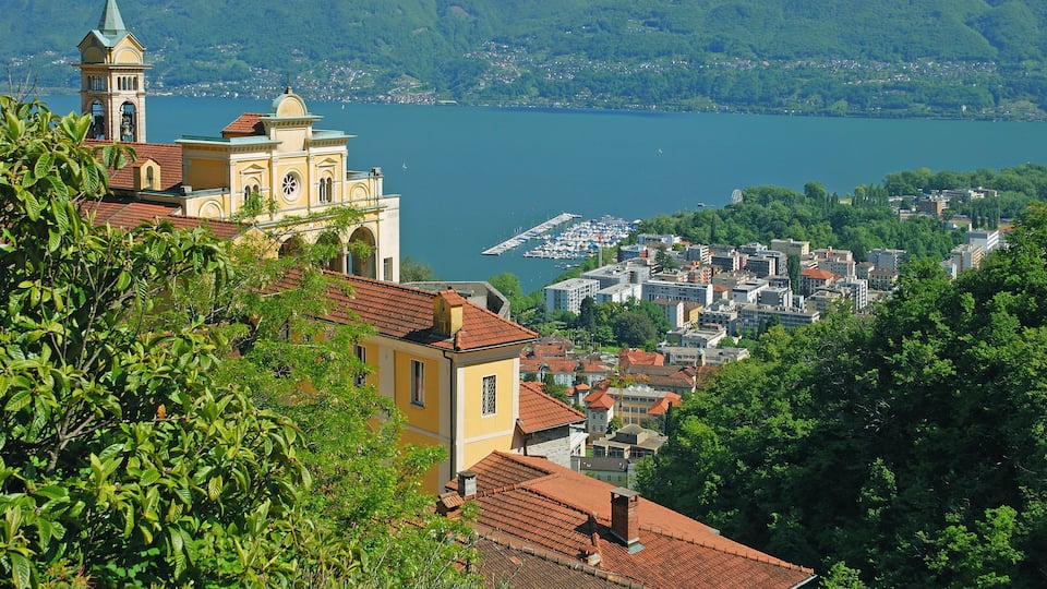 A coastal town with a prominent church, a marina, and lush greenery.