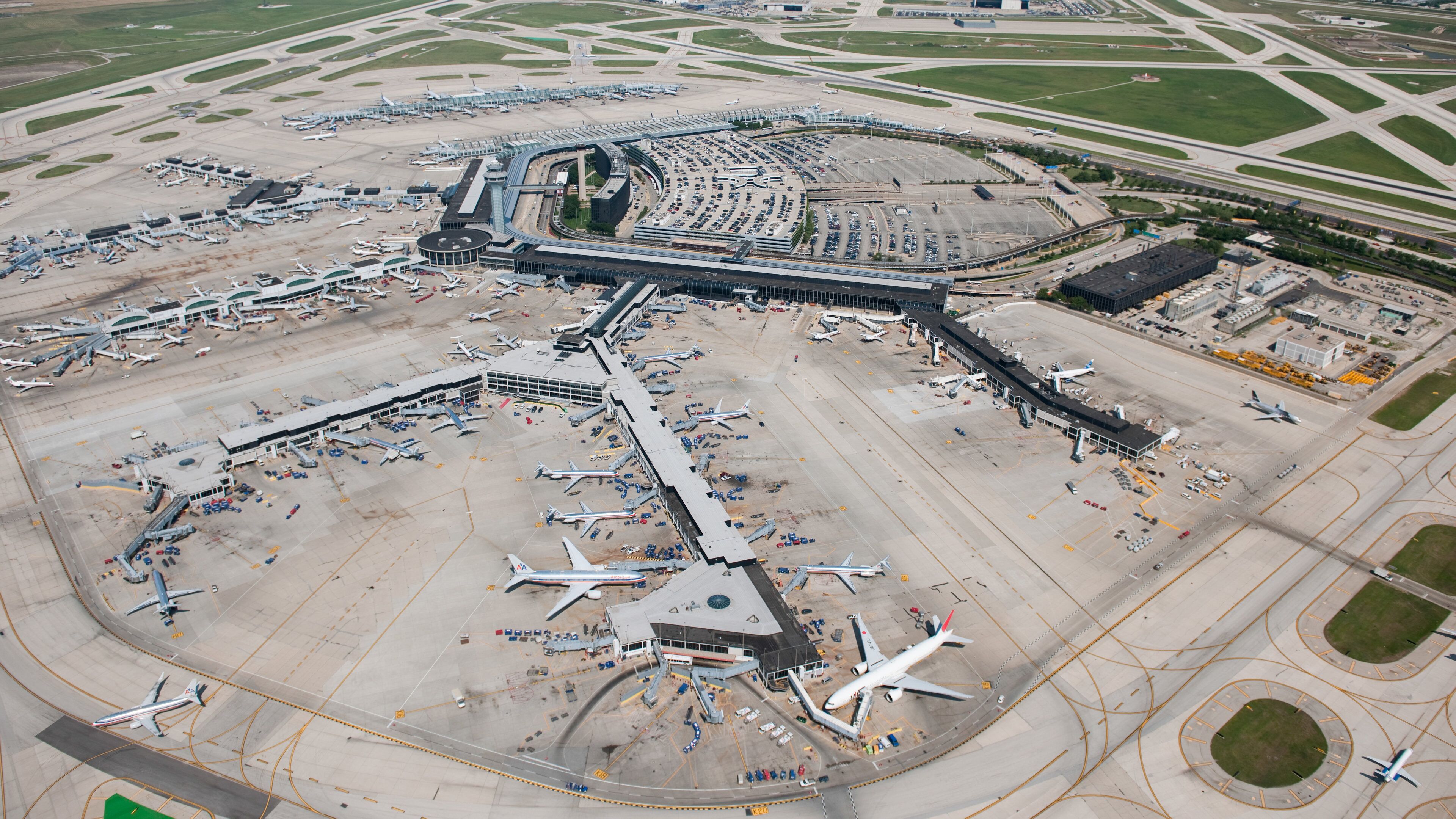 An airport with multiple runways, terminal buildings, and parked airplanes.