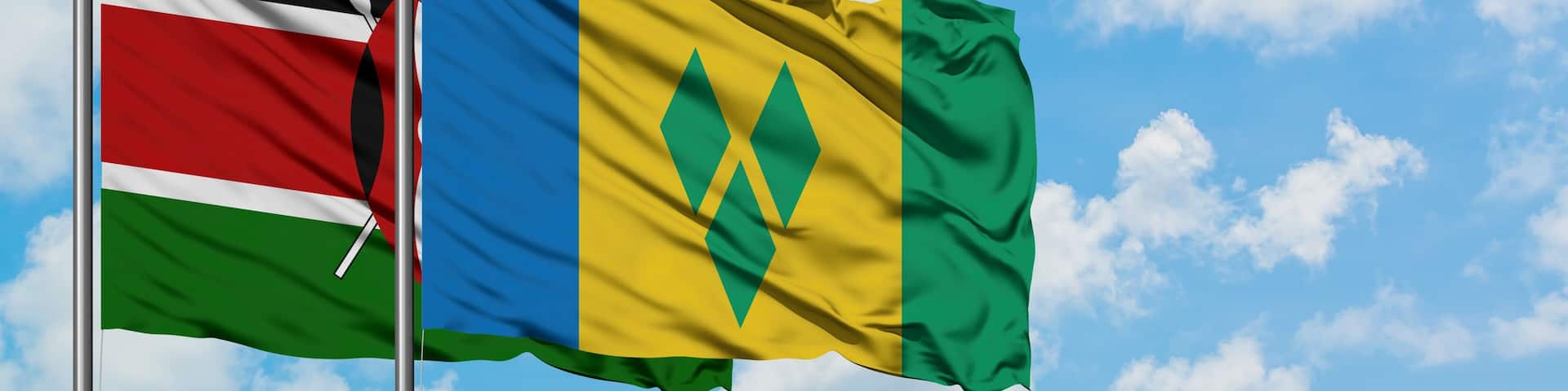 Kenya and Saint Vincent And The Grenadines flag waving in the wind against white cloudy blue sky together. Diplomacy concept, international relations.