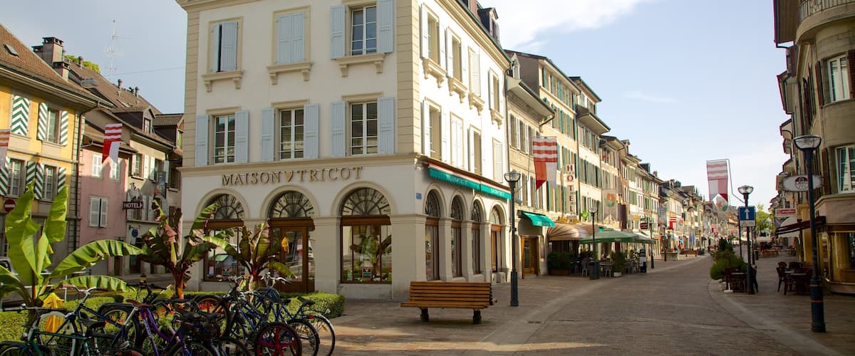 A historic building labeled "MAISON VICTOR" on a cobblestone street with bicycles parked in front and outdoor seating in the background.