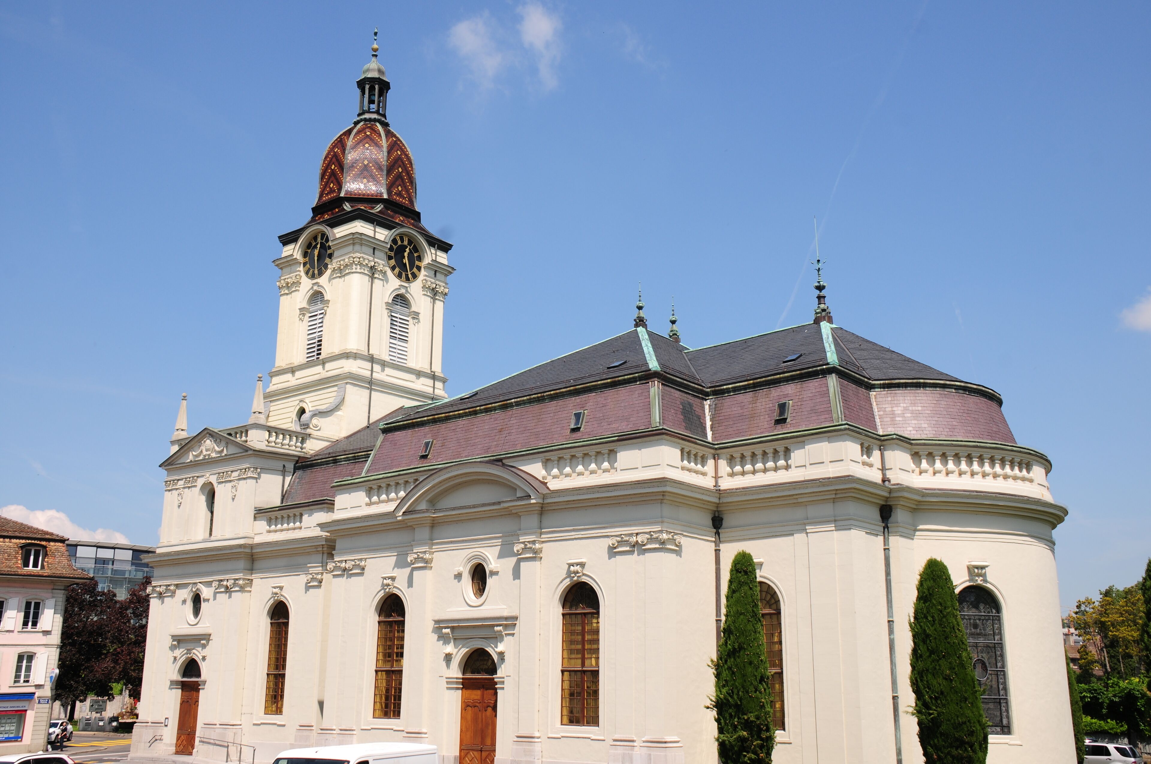 A historic church with a prominent clock tower and a dome.