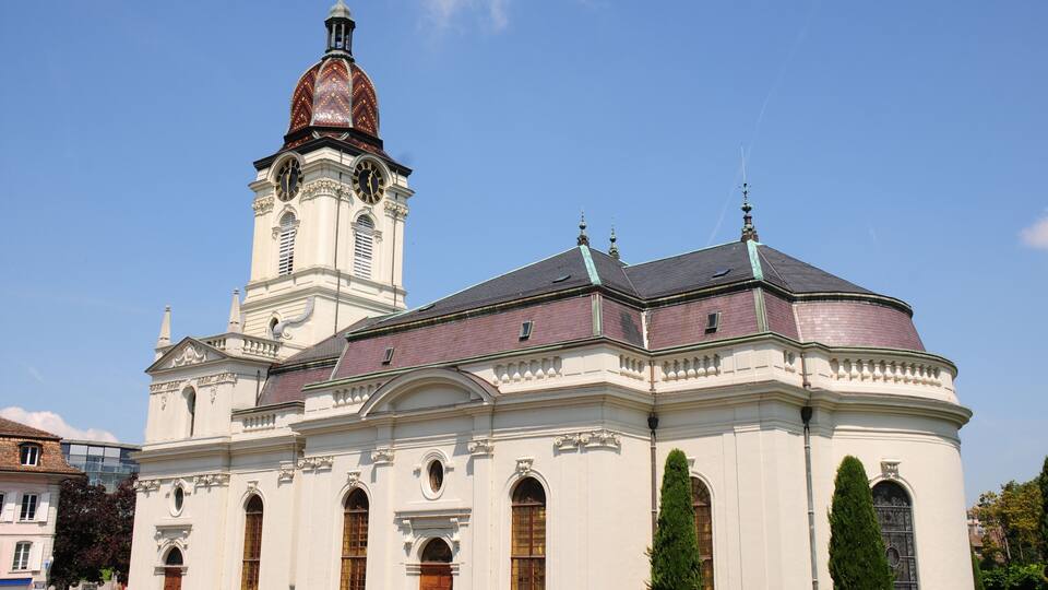 A historic church with a prominent clock tower and a dome.