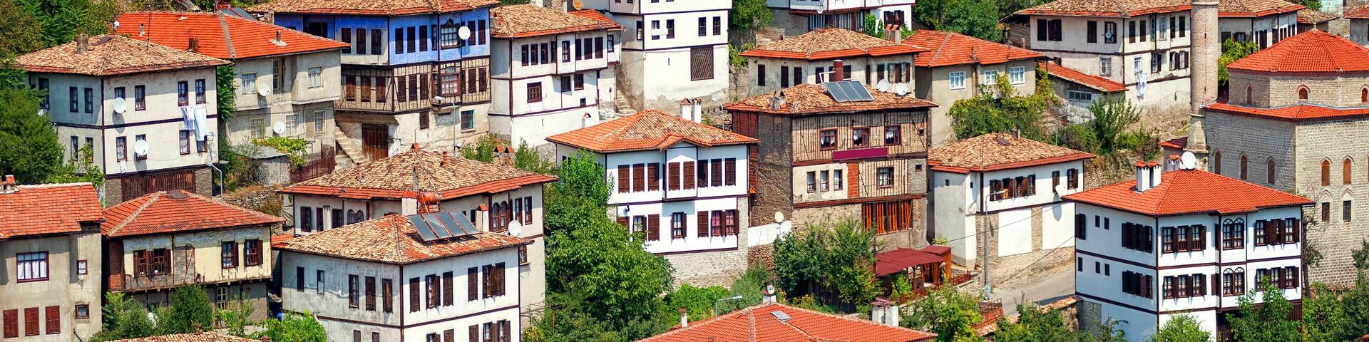 A hillside village with traditional red-tiled roofs and white-washed buildings.