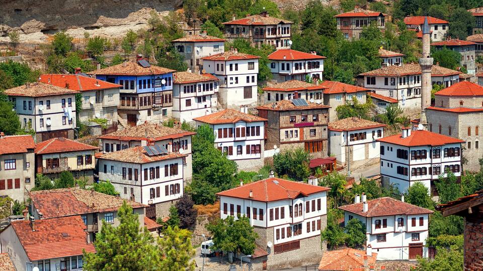 A hillside village with traditional red-tiled roofs and white-washed buildings.