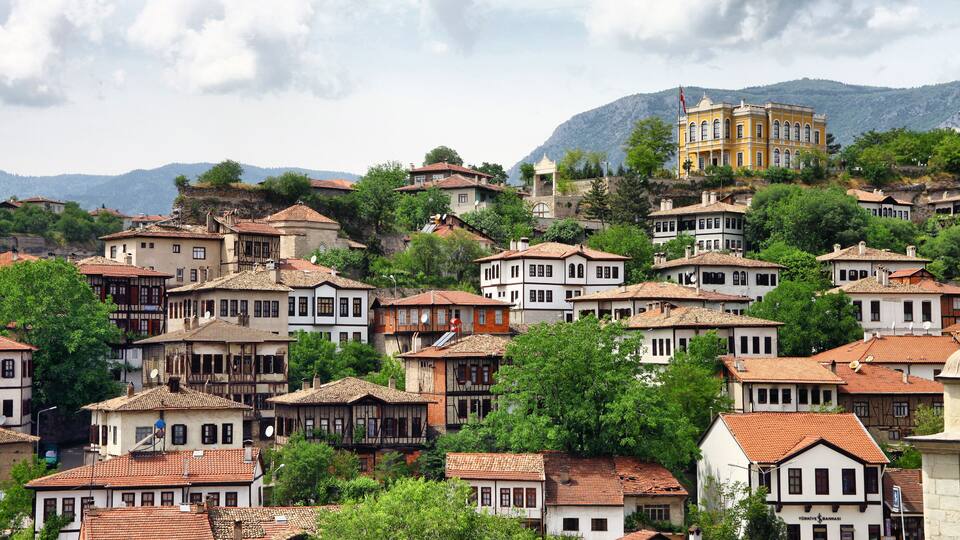 A hillside town with historic buildings and a prominent yellow building on a hill.