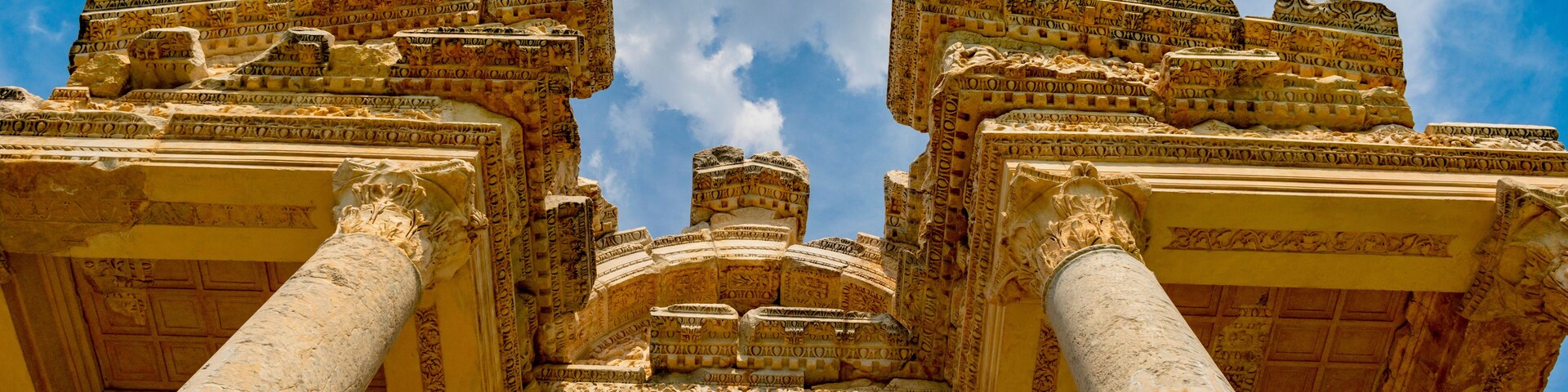 Columnas antiguas con intrincados grabados y un cielo azul intenso.