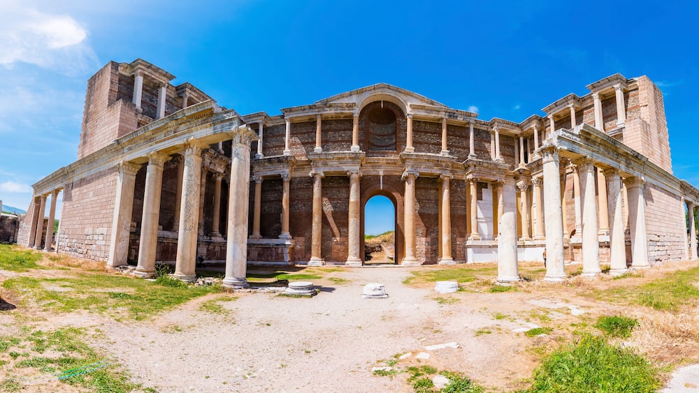 An ancient Roman amphitheater with columns and an arched entrance.