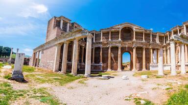 Un antiguo anfiteatro romano con columnas y una entrada en arco.