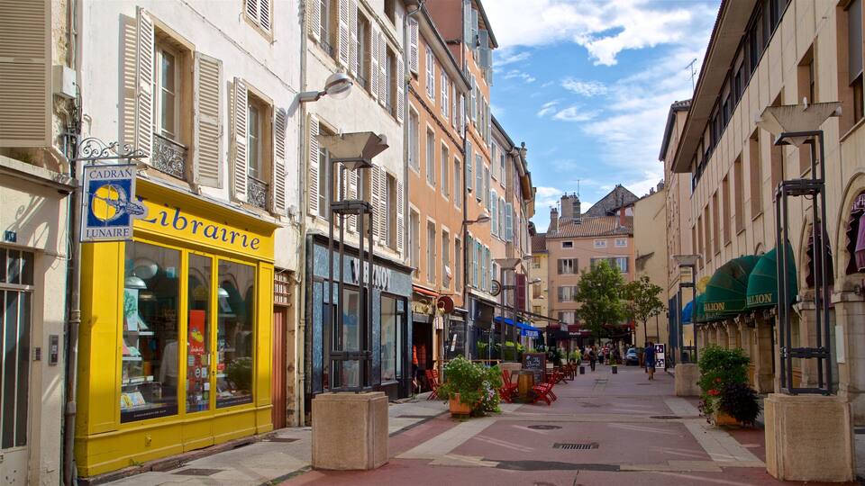 A street with shops, including a yellow storefront with 'brairie' signage, and a building with 'LUNAIRE' signage.