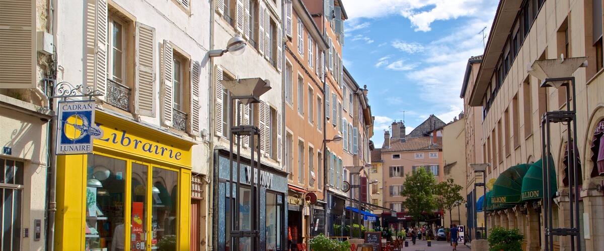 A street with shops, including a yellow storefront with 'brairie' signage, and a building with 'LUNAIRE' signage.