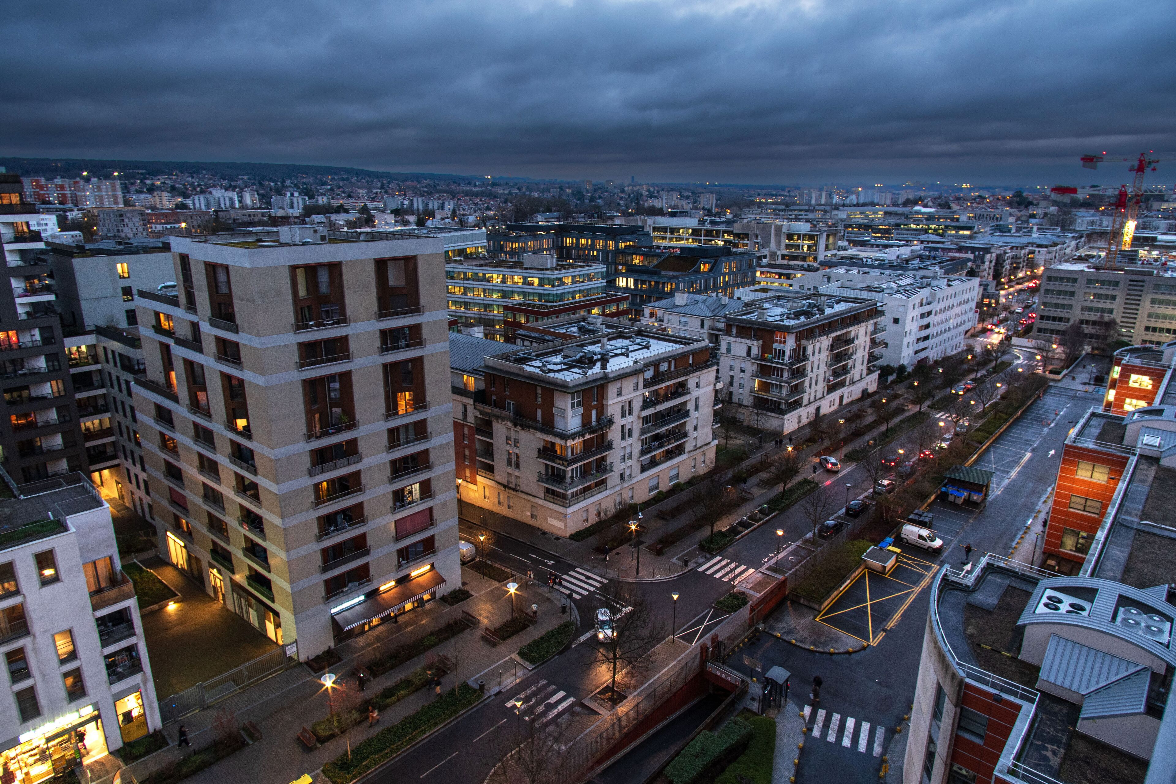 The town of Massy with its residential and industrial buildings lit up at night in the Parisian suburbs in France