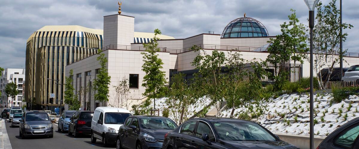 A modern building with a dome and a tall, striped structure.