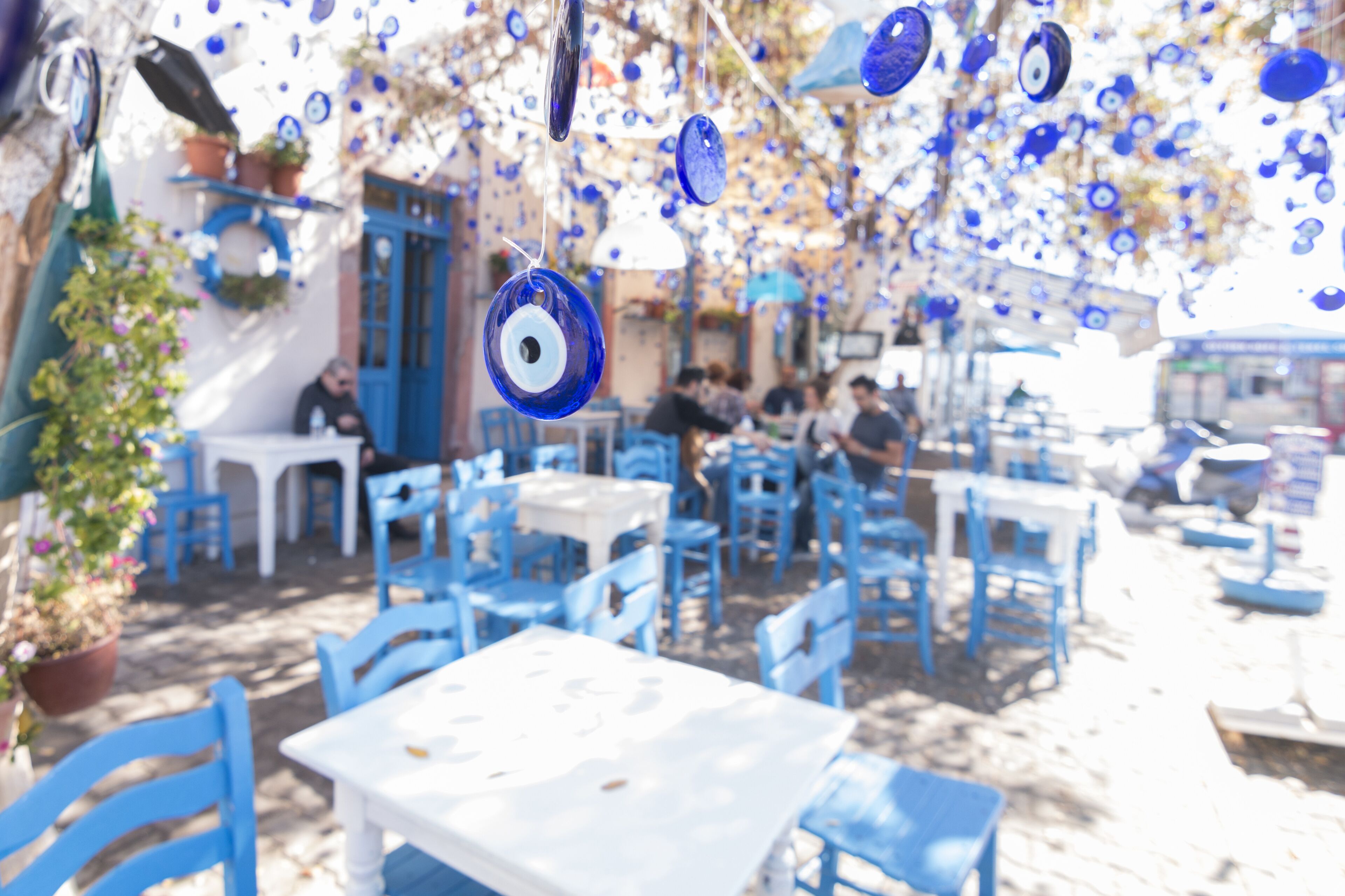 CUNDA ISLAND, AYVALIK, TURKEY - October 16, 2017: Evil eyes are hung in decorative purpose with a tree on the background in Cunda Alibey Island, Ayvalik.