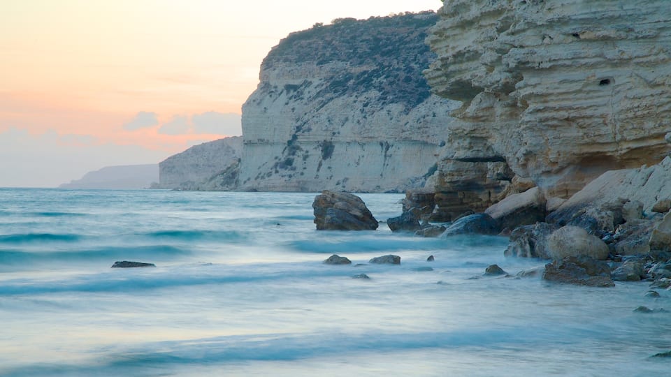 A coastal scene with white cliffs and calm sea.