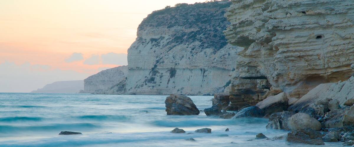 A coastal scene with white cliffs and calm sea.