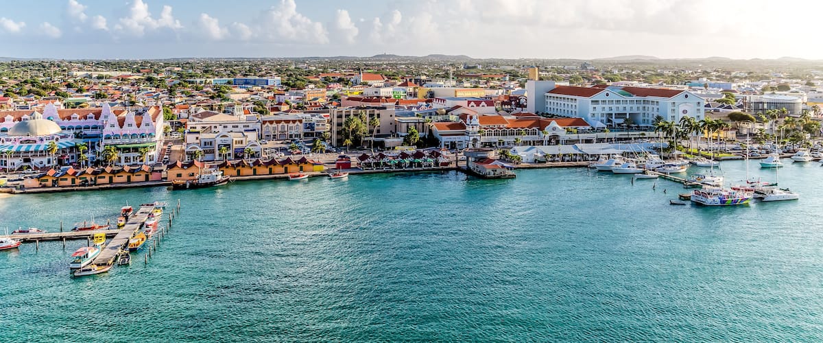 A coastal town with a marina, colorful buildings, and a clear blue sky.