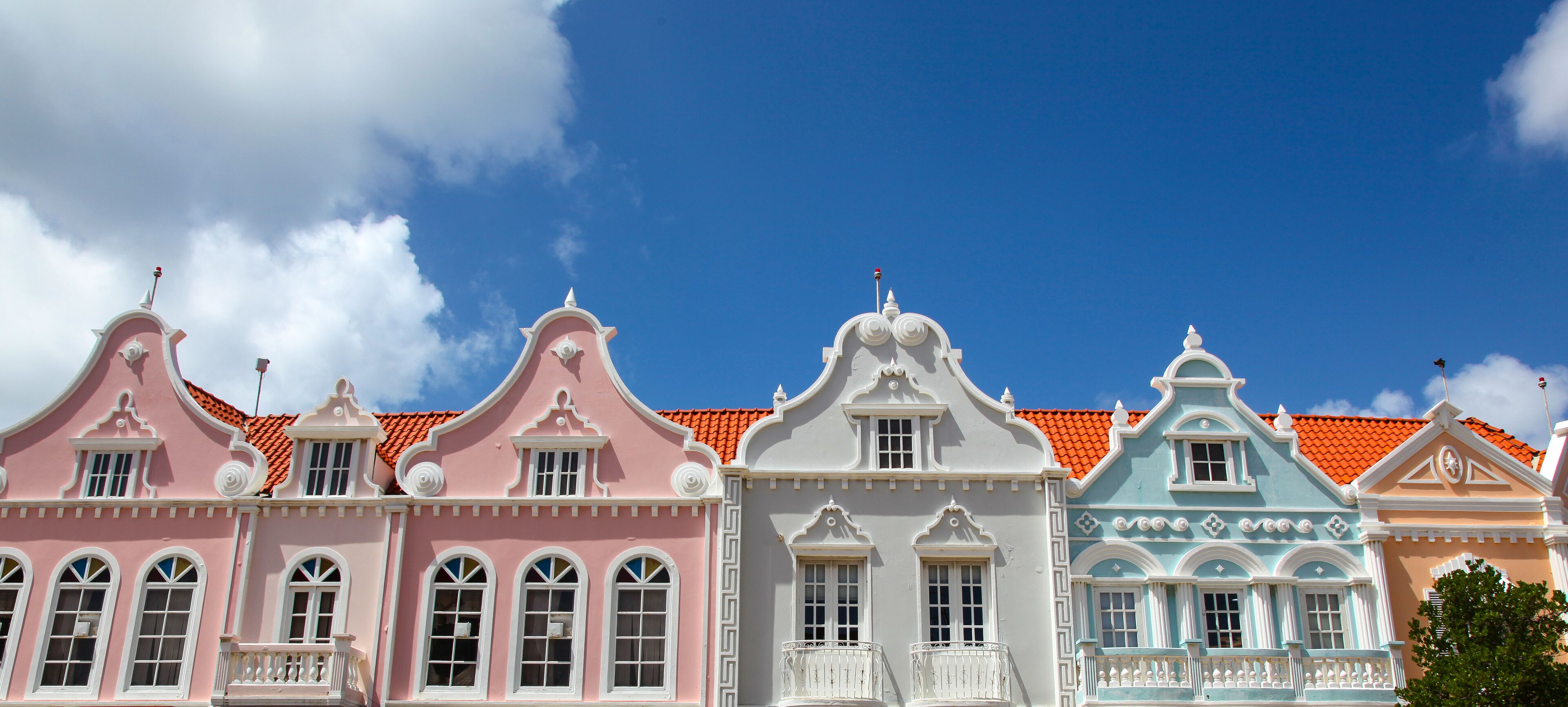 Row of colorful pink, blue and white building facades of Oranjestad Aruba
