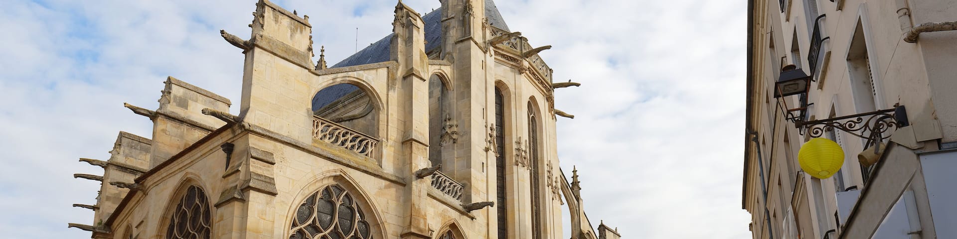 A historic church with ornate architecture, a cobblestone street, and a clear sky.
