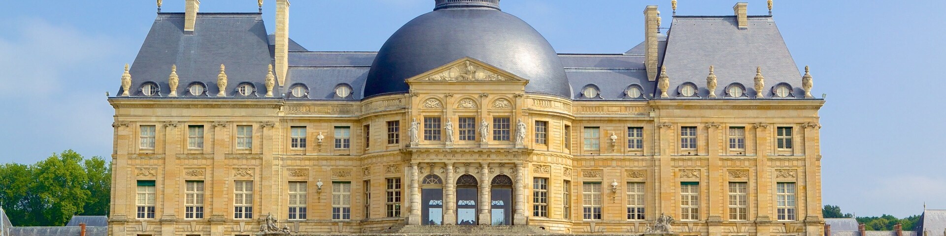 Un edificio grande e histórico con una cúpula destacada y arquitectura simétrica.