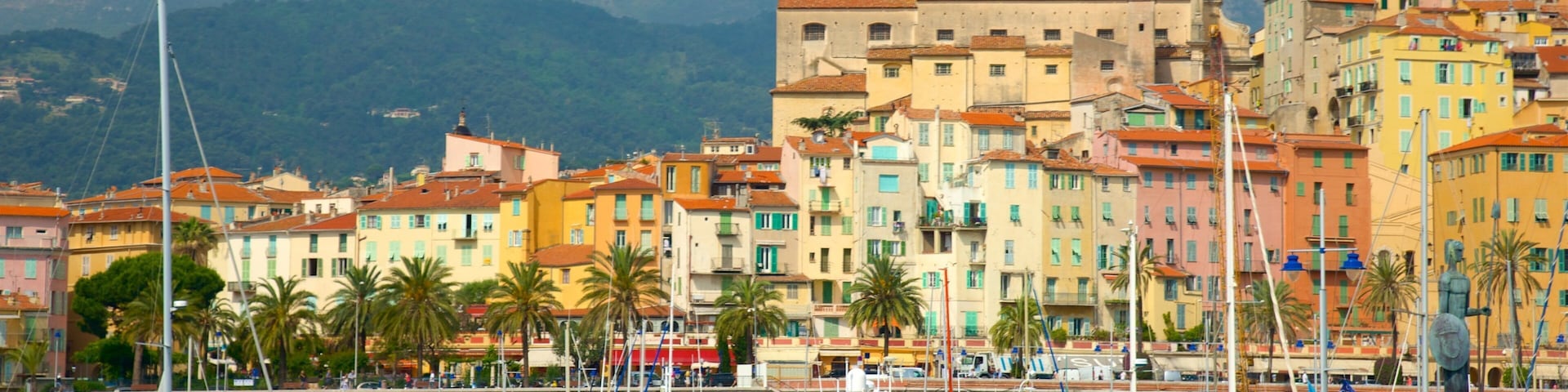 A marina with boats, colorful buildings, and a prominent tower in the background.