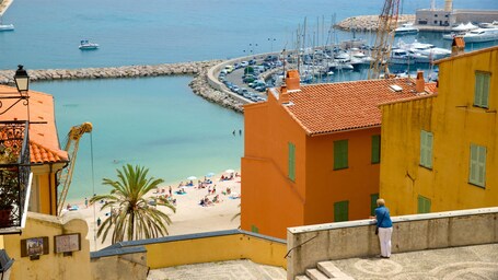 Une ville côtière avec une plage, des bateaux et des bâtiments aux couleurs vives.
