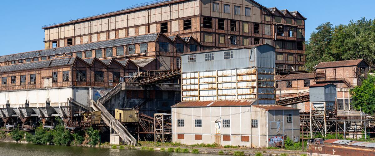 An industrial complex with large buildings and a river.
