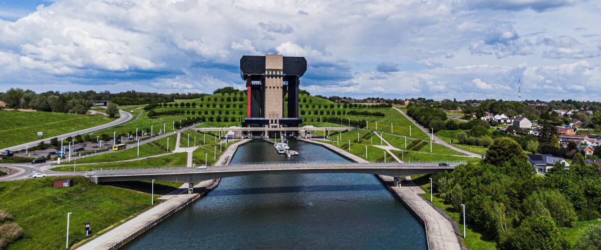 A large water tower with a bridge crossing over a canal.