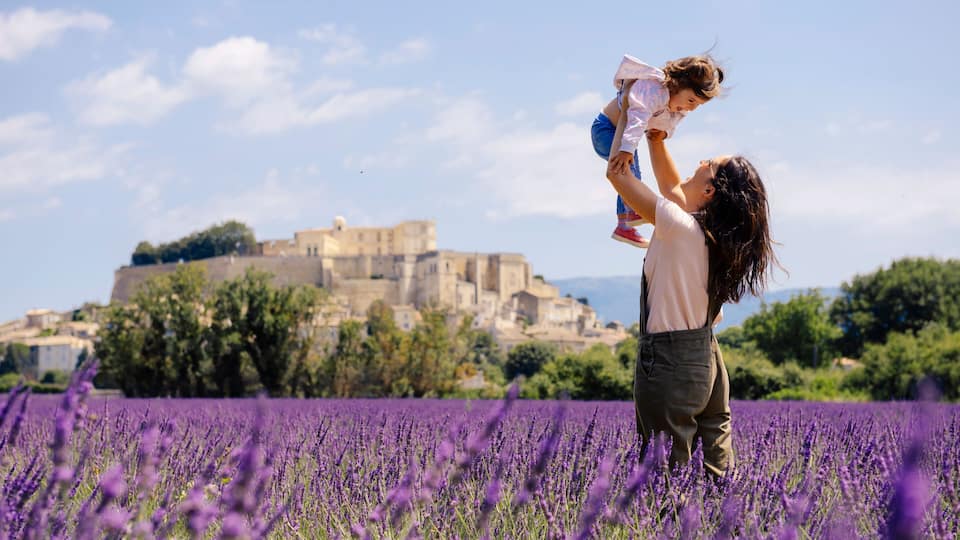 A lavender field with a historic building in the background.