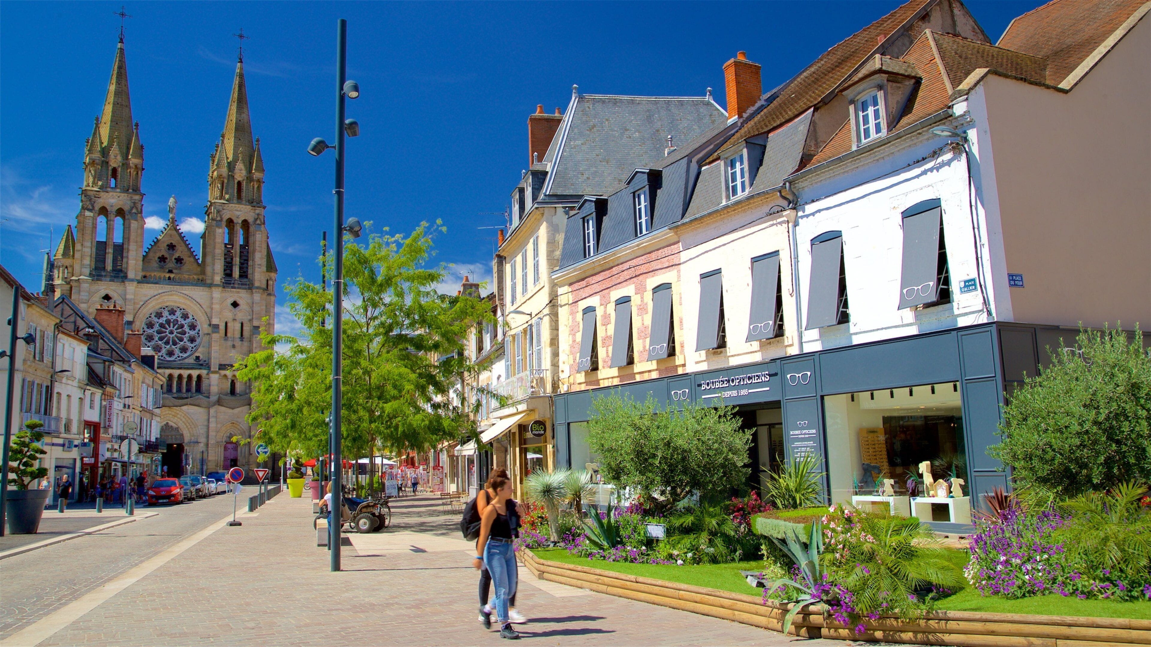 A street with historic buildings, a church, and a boutique.