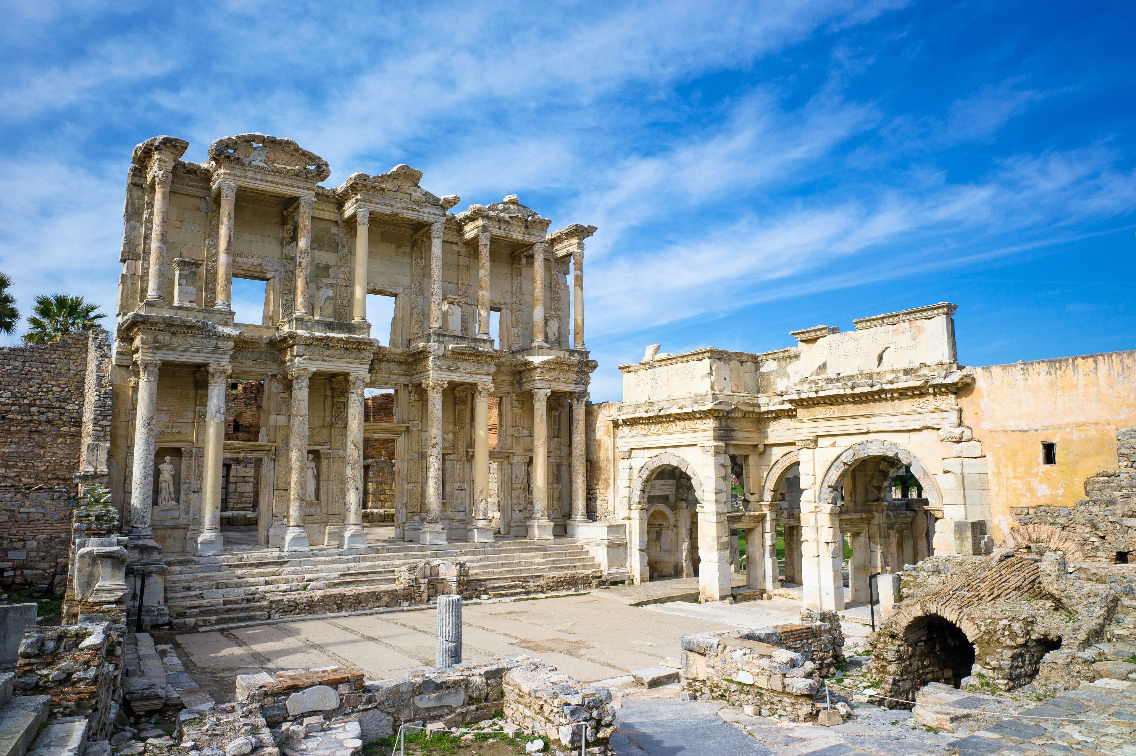 The ruins of an ancient structure with columns and arches.