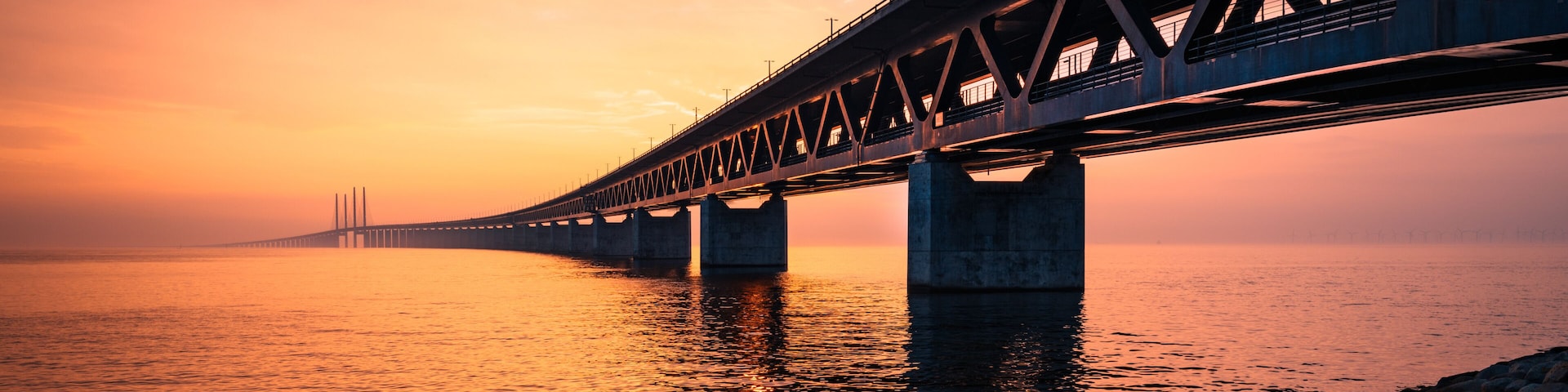 Un puente cruzando un cuerpo de agua al atardecer.