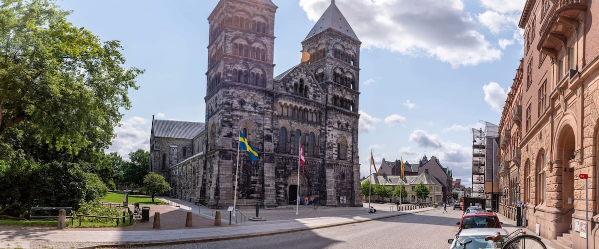 A historic church with twin towers, surrounded by cobblestone streets and greenery.