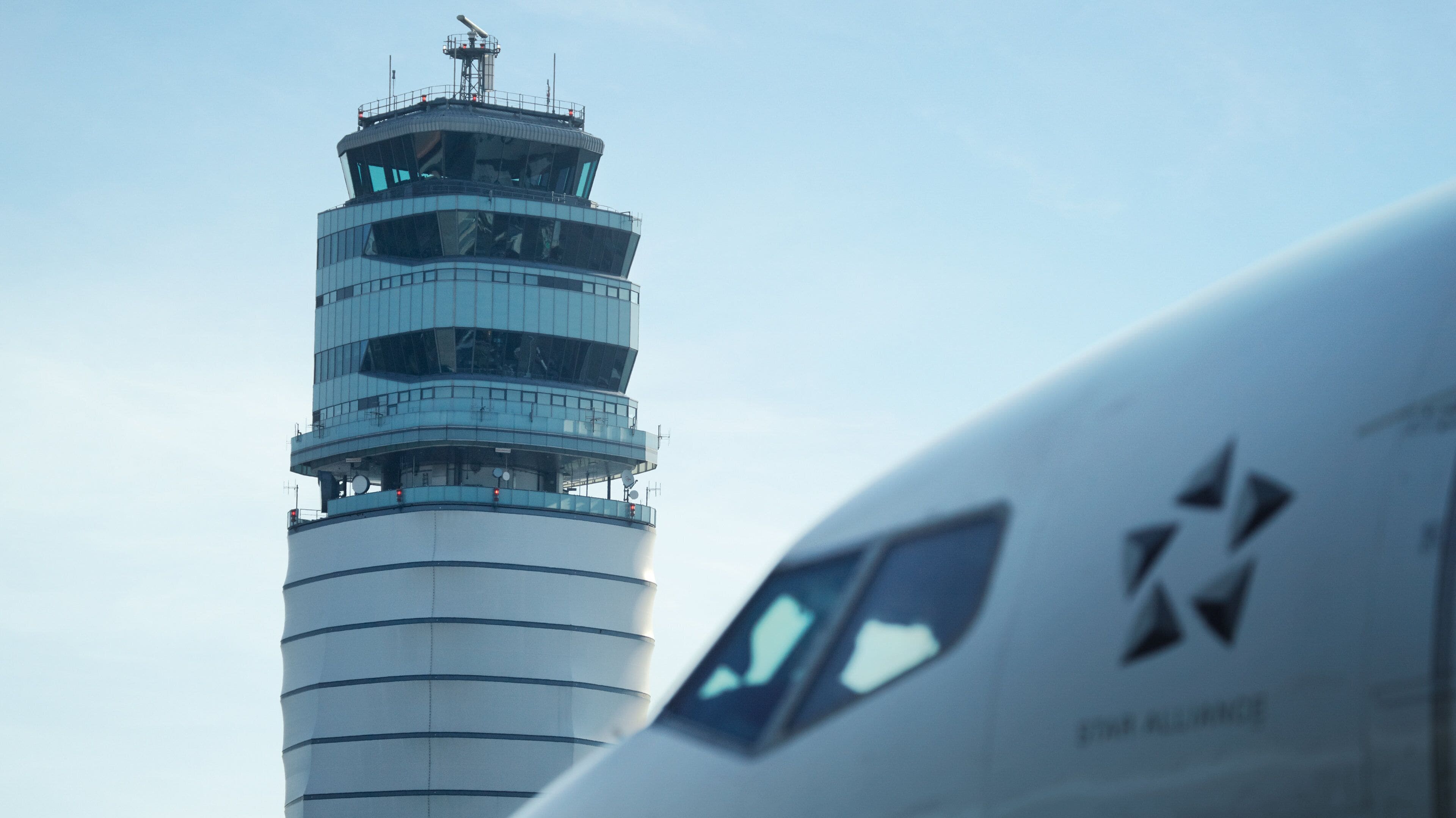 An airport control tower and part of an airplane.