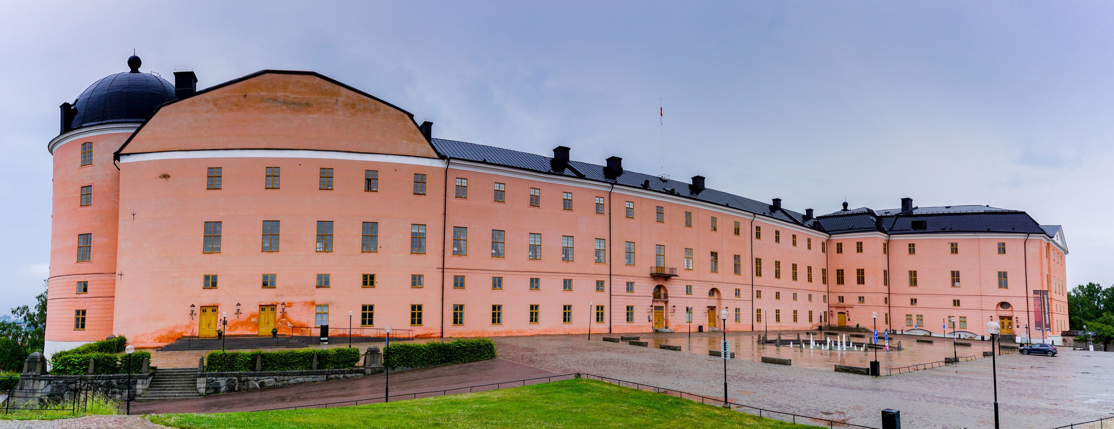 A large pink building with a dome and multiple windows.