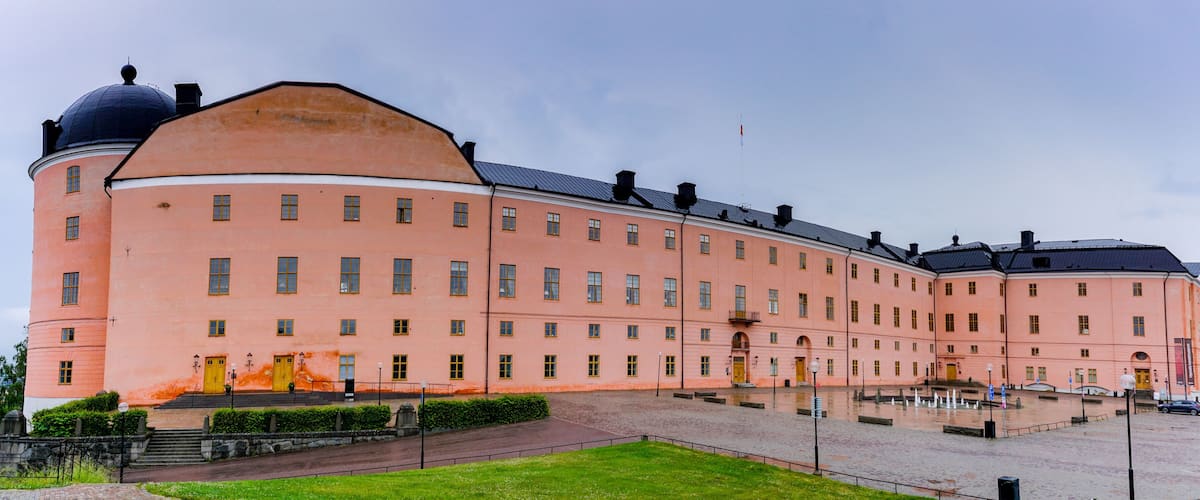 A large pink building with a dome and multiple windows.