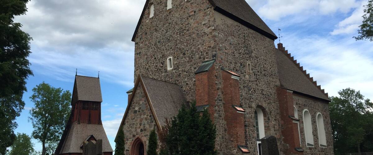 A large stone church with a steep roof and a smaller adjacent structure.