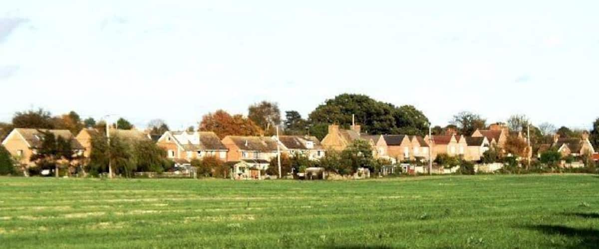 A residential area with houses and a green field.