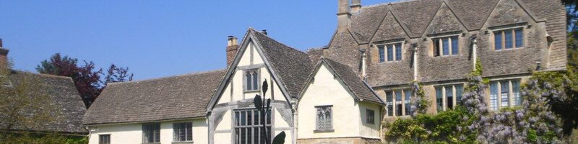 Una casa grande e histórica con un césped impecable y un cielo azul despejado.