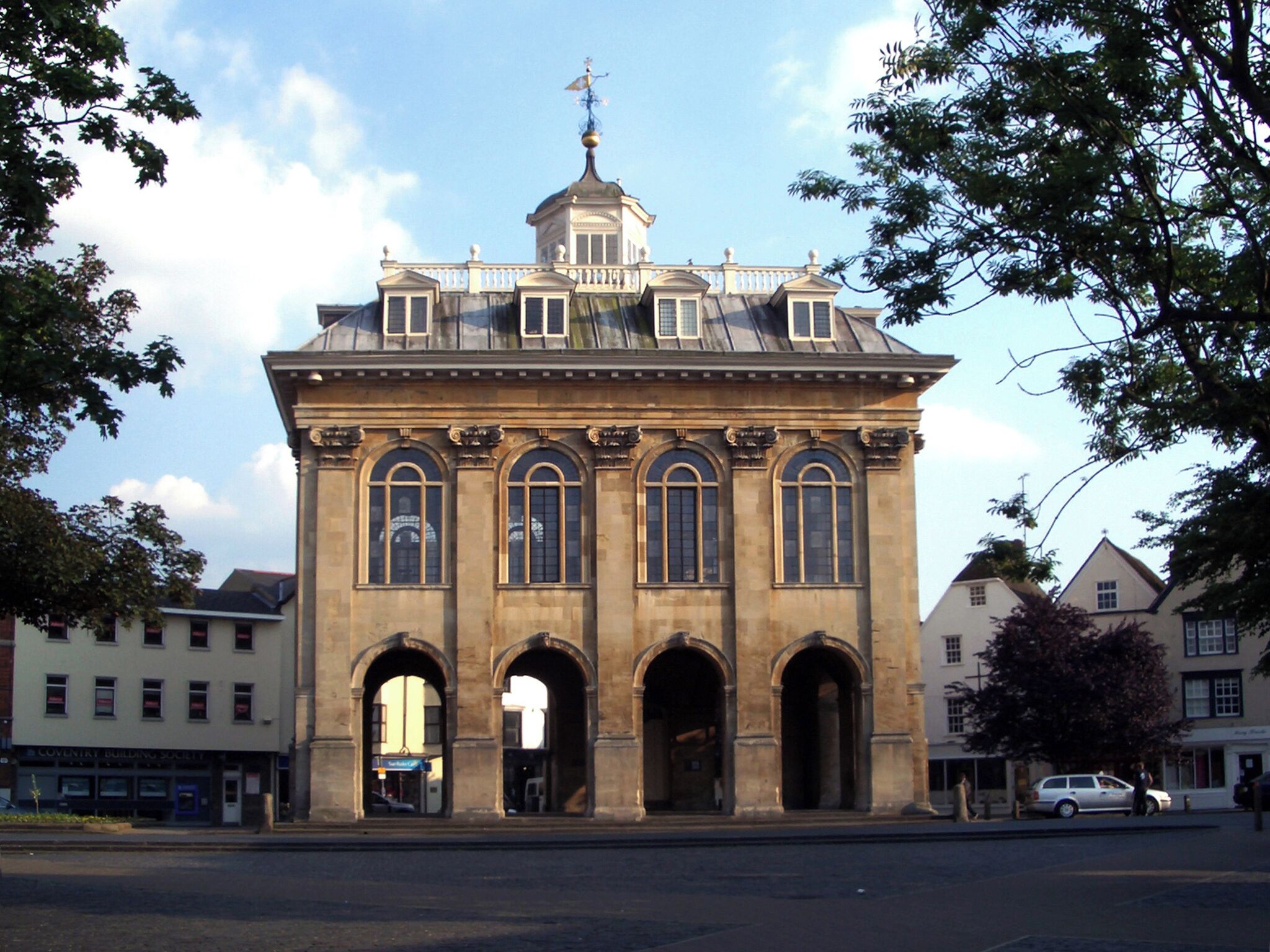 A historic building with a central dome, arched windows, and a weather vane.