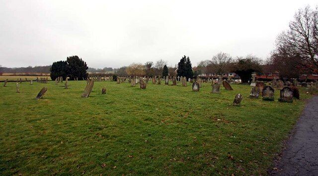 A cemetery with numerous headstones and trees.