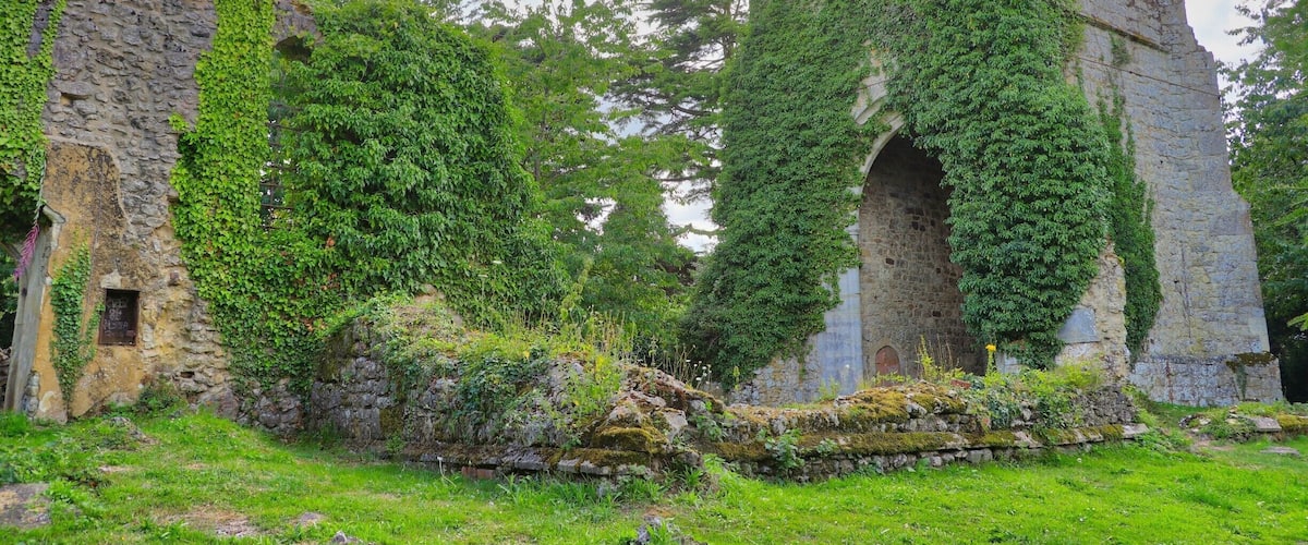 An ancient stone structure with ivy-covered walls and a tall tower.