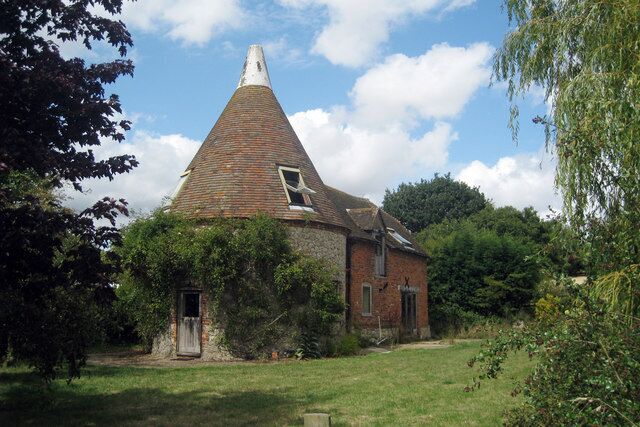 A conical-roofed building surrounded by greenery.