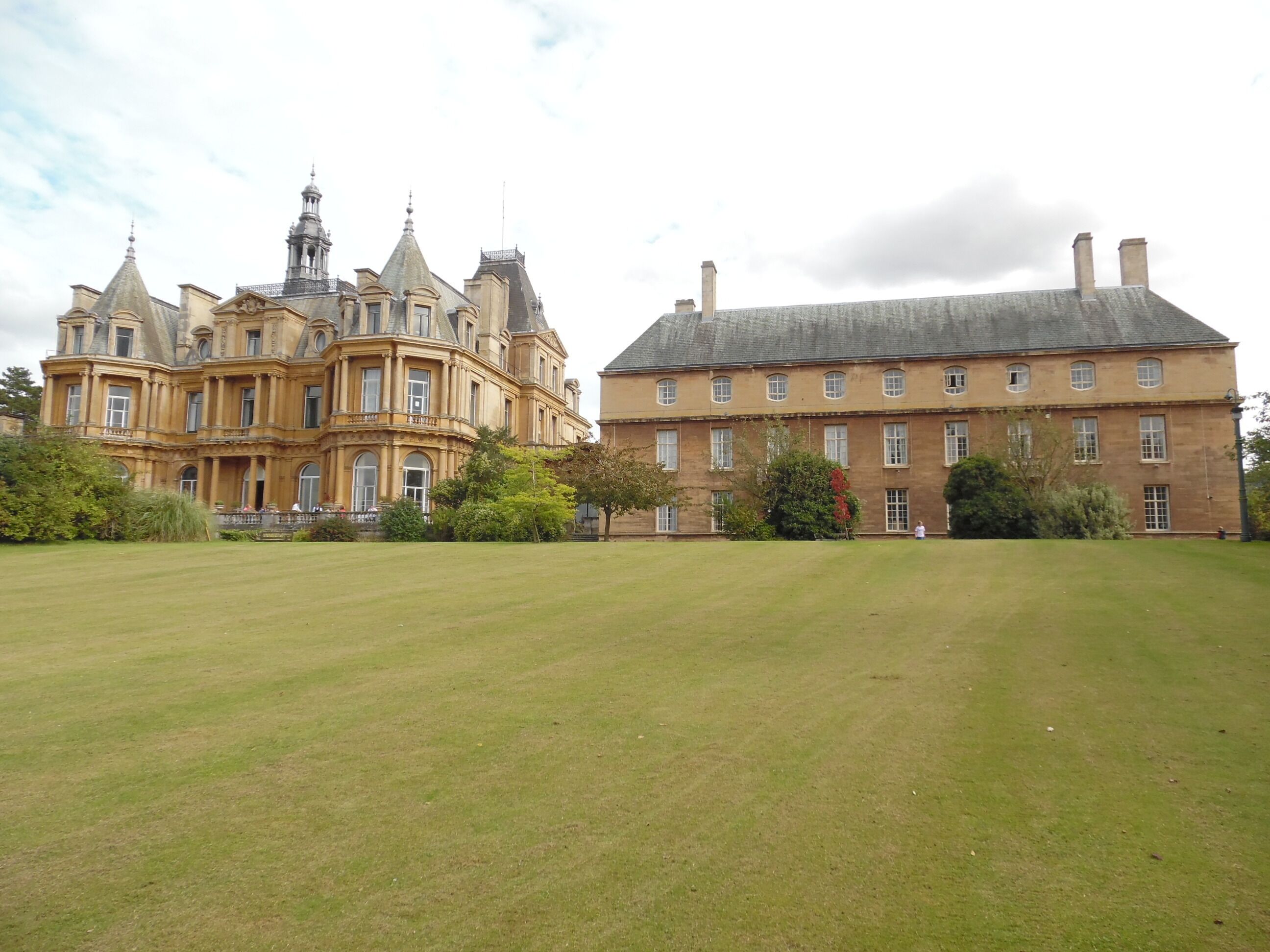 A large, ornate building with a prominent tower and a smaller, simpler structure beside it.