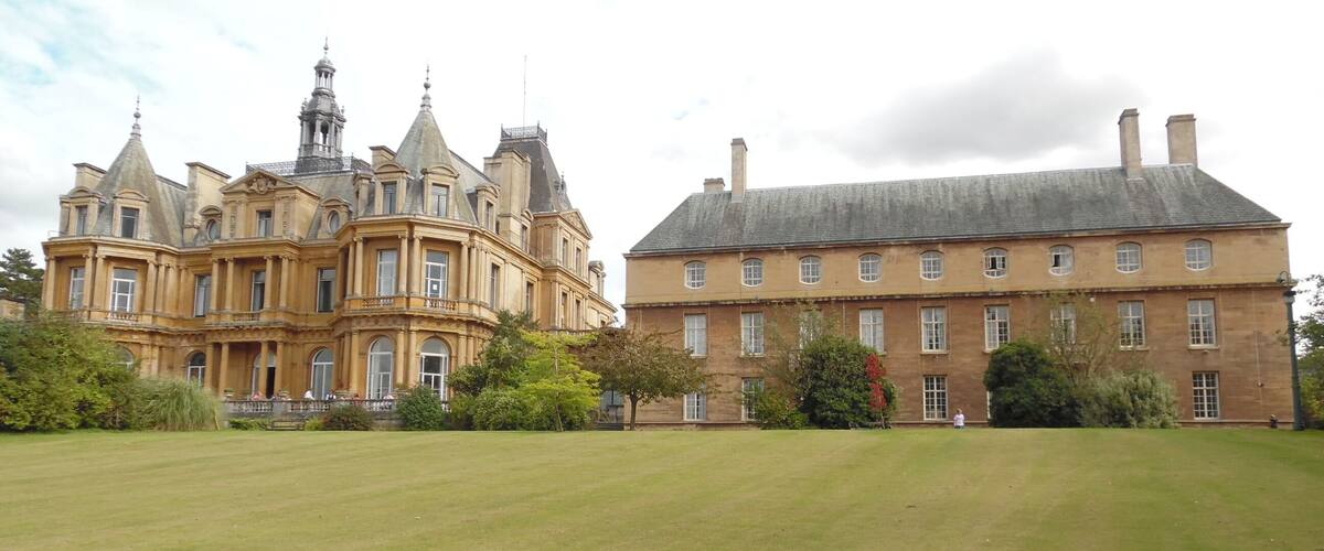 A large, ornate building with a prominent tower and a smaller, simpler structure beside it.