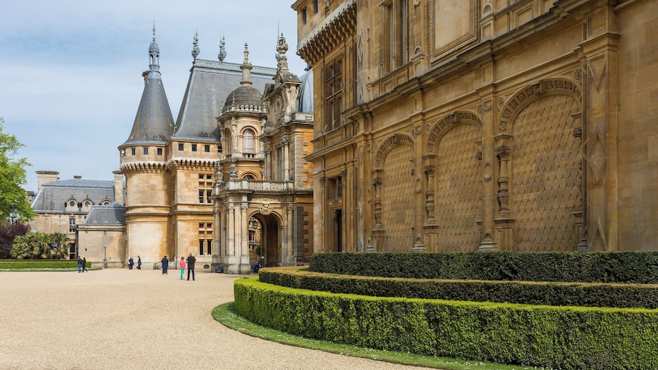 A historic building with ornate architecture and a well-manicured garden.