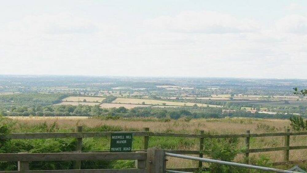 Vue sur la campagne depuis un point de vue élevé, avec un panneau indiquant : « Midgewell Mill, chemin privé ».
