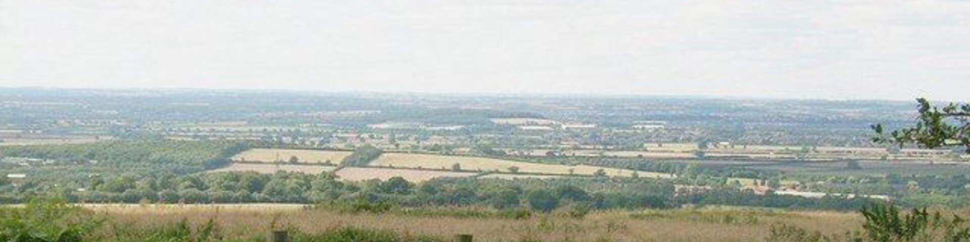 View from top of Muswell Hill, near Brill The stunning view of the flat landscape below towards Bicester, from the top of Muswell Hill. This hill peaks at a slightly higher altitude than neighbouring Brill Hill by approx 12 metres. Note the large structures of Bullingdon Prison and the MOD site at Arncott around the centre of the background.