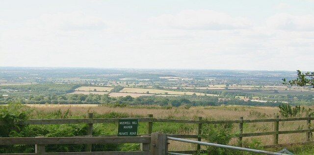 A view of the countryside from a high vantage point with a sign indicating 'Midgewell Mill, Private Road'.