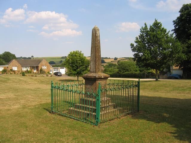 Sutton-under-Brailes war memorial. This memorial to victims of the 1st World War is situated on the green in Sutton-under-Brailes. Some of the more modern houses in the village can be seen on the far side of the green.