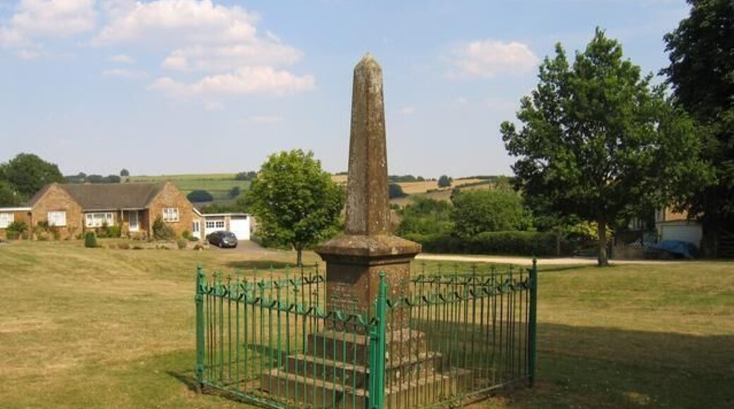 Sutton-under-Brailes war memorial. This memorial to victims of the 1st World War is situated on the green in Sutton-under-Brailes. Some of the more modern houses in the village can be seen on the far side of the green.